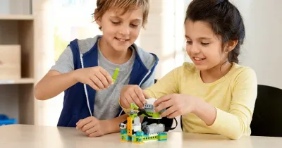 Двое детей собирают модель робота из набора WeDo 2.0