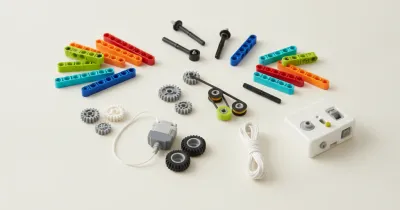 Детали конструктора, совместимого с WeDo 2.0, разложенные группами: балки, шестерни, оси, ремни и шины